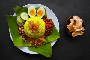 nasi kuning eller gul ris eller tumör ris är traditionell mat från Asien, tillverkad ris kokta med gurkmeja, kokos mjölk r foto