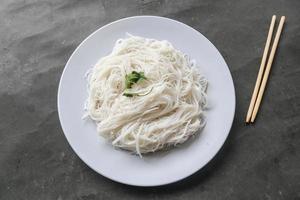 bihun eller vermiceller eller ris spaghetti eller ängel hår eras på tallrik isolerat på svart bakgrund foto