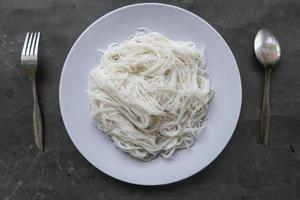 bihun eller vermiceller eller ris spaghetti eller ängel hår eras på tallrik isolerat på svart bakgrund foto
