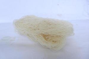 rå torr bihun eller vermiceller eller ris spaghetti eller ängel hår isolerat på vit bakgrund foto