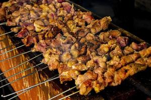 sate klatak eller sate kambing eller satay get, lamm, lamm eller kött get satay med träkol ingrediens på röd brand grillning förbi människor, indonesien matlagning satay. med selektiv fokus foto