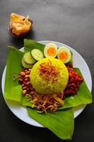 nasi kuning eller gul ris eller tumör ris är traditionell mat från Asien, tillverkad ris kokta med gurkmeja, kokos mjölk r foto