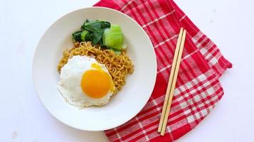 omedelbar spaghetti eras med ägg friterad och senap grönt på tallrik. omedelbar friterad nudel indomie foto