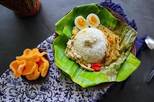 nasi liwet solo- eller sego liwet solo- är en traditionell mat från surakarta. tillverkad från välsmakande ris, chayote och kokt ägg, kyckling, tjock kokos mjölk eras på en banan blad foto