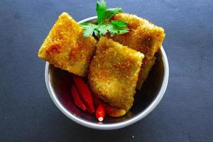 friterad risoles eller risol mayo är indonesiska snacks. tycka om coxinha de galinha. eras med chili sås, selleri på trä styrelse foto