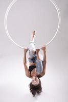 en kvinna antenn ring gymnast utför övningar på ett antenn ring foto
