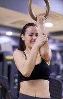 kvinna håller på med en träna med hantlar på de kondition Gym. foto