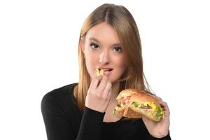 porträtt av en skön rolig ung flicka äter hamburgare. foto