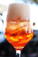 glas med uppfriskande juice på de bar. citrus- cocktail över is, orange cocktail detaljer foto