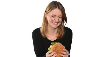 porträtt av en skön rolig ung flicka äter hamburgare foto
