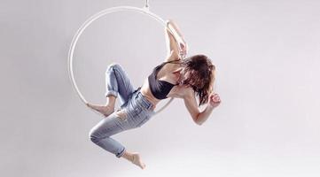en kvinna antenn ring gymnast utför övningar på ett antenn ring foto