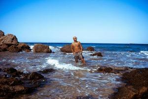 stilig man på de marin klippig Strand foto