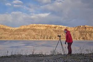 senior manlig fotograf med en kamera på stativ foto