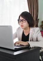 kvinna arbetssätt på bärbar dator i Hem kontor foto