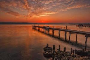 fantastisk solnedgång på de hamn med trä- pir foto