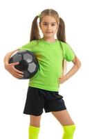 charmig ung flicka i grön skjorta med boll i händer foto