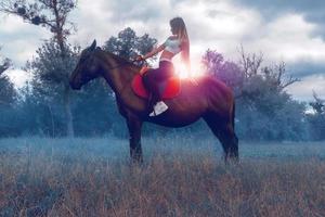 en charmig ung ryttare sitter grensle en häst foto
