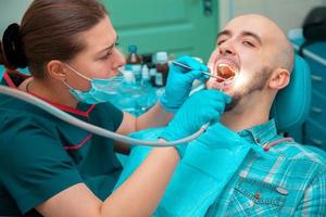 trevlig man gör förebyggande av karies på dental kontroller foto