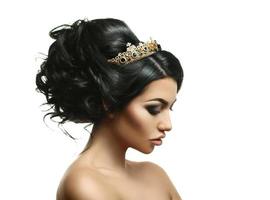 profil porträtt av skönhet ung brunett med kreativ frisyr och krona på huvud foto
