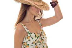 ung söt brunett flicka i sarafan med blommig mönster och sugrör hatt med bred brätte Framställ med Dölj ögon isolerat på vit bakgrund foto