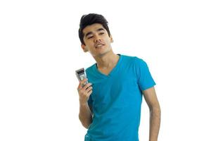 glada ung brunett man i blå t-shirt och trimmer i hand leende foto