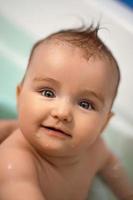 söt nyfödd flicka badar i de badrum foto