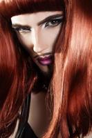 vertikal porträtt av skön rött hår man med magenta smink foto