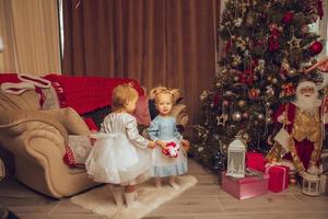 två liten spädbarn flickor med en jul träd från Bakom foto