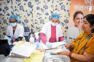 delhi, Indien - november 19, 2022 -stänga upp av kvinna tandläkare håller på med rutin- dental kolla upp till patient, patient liggande på stol på årlig hälsa kolla upp, tandläkare håller på med dental kolla upp till patient foto