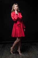 sexig blondin i röd klänning i studio foto