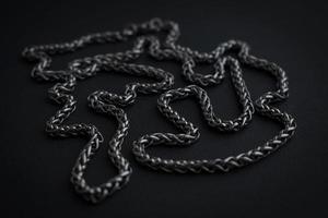 metallisk halsband på svart bakgrund. silver- Färg kedja. mörk kall Färg Foto. herr- halsband. tjock kedja. manlig halsband. rostfri Smycken. halsband detalj. foto