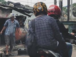 jakarta, indonesien i juli 2022. två män var byter ut en blåst lastbil däck. foto