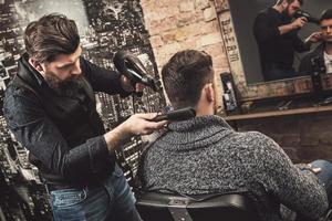 frisör under arbete med en kille klient i de frisör foto
