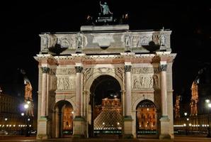 båge de triomphe du karusell mot de bakgrund av de louvre museum i paris, Frankrike på natt. foto