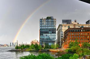 regnbåge över lägenhet byggnader i dumbo längs brooklyn bro parkera. foto