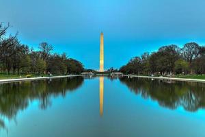 Washington monument reflekterande i de lincoln minnesmärke reflekterande slå samman på solnedgång i Washington, dc. foto