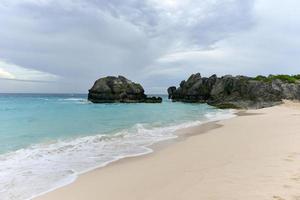 klar vatten och rosa sand av jobson cove strand i bermuda. foto