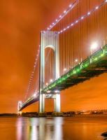 verrazano narrows bro på natt från Brooklyn. de bro en dubbeldäckad suspension bro den där ansluter de stadsdelar av staten ö och brooklyn i ny york stad på de smalnar av. foto
