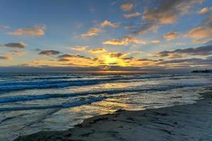 vågor längs de strand på pacific strand på solnedgång i san diego, kalifornien foto