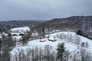 antenn se av en bondgård och ladugård i lantlig vermont på en snöig dag. foto