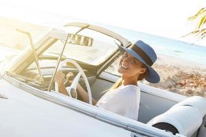 skön kvinna i blå hatt och vit retro cabriolet foto