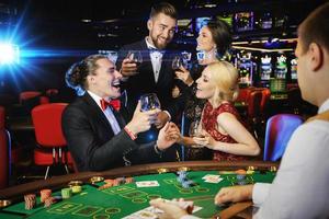 Lycklig människor fira deras vinna efter framgångsrik spel i de kasino foto