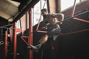 stark man håller på med muskel upp övning i de korsa Träning Gym foto