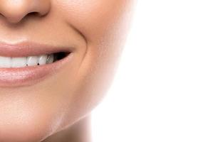 skön kvinna leende med vit tänder mot vit bakgrund foto