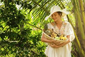 skön kvinna bär bredbrättad hatt i de tropisk trädgård foto