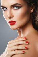 porträtt av skön ung kvinna med en röd läppstift och nagel putsa foto