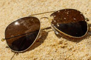 solglasögon på sanden foto