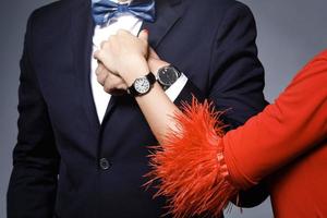 närbild av väl klädd eleganta par bär armbandsur foto