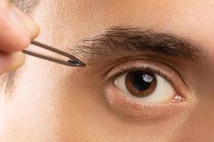 manlig öga och pincett för ögonbryn form korrektion foto