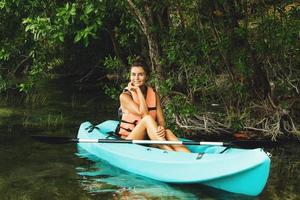 Lycklig ung kvinna Kajakpaddling på de sjö foto